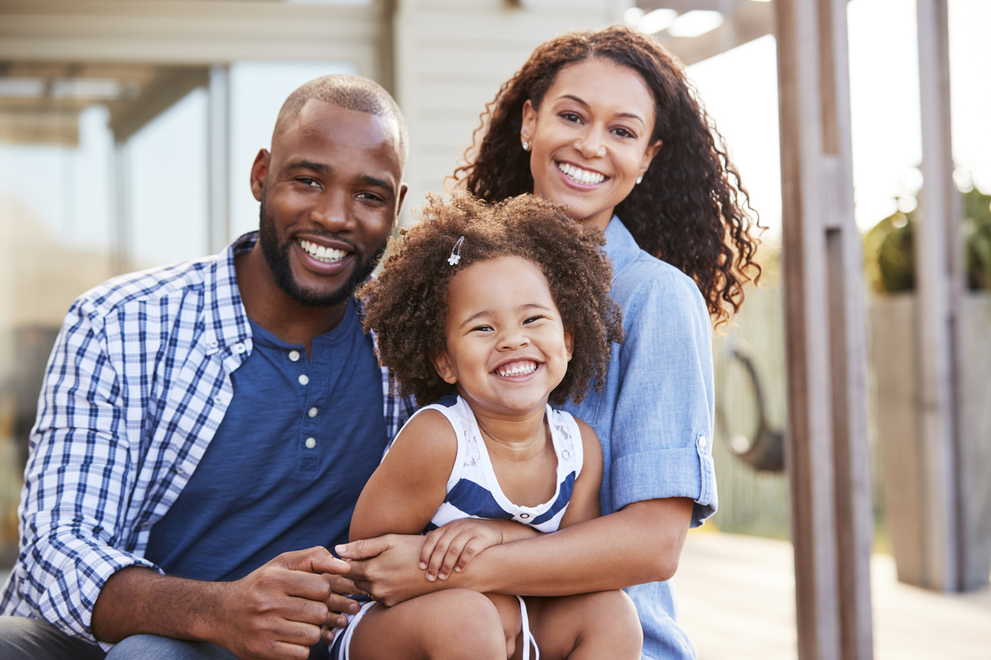 Father, mother and daughter sitting down and smiling